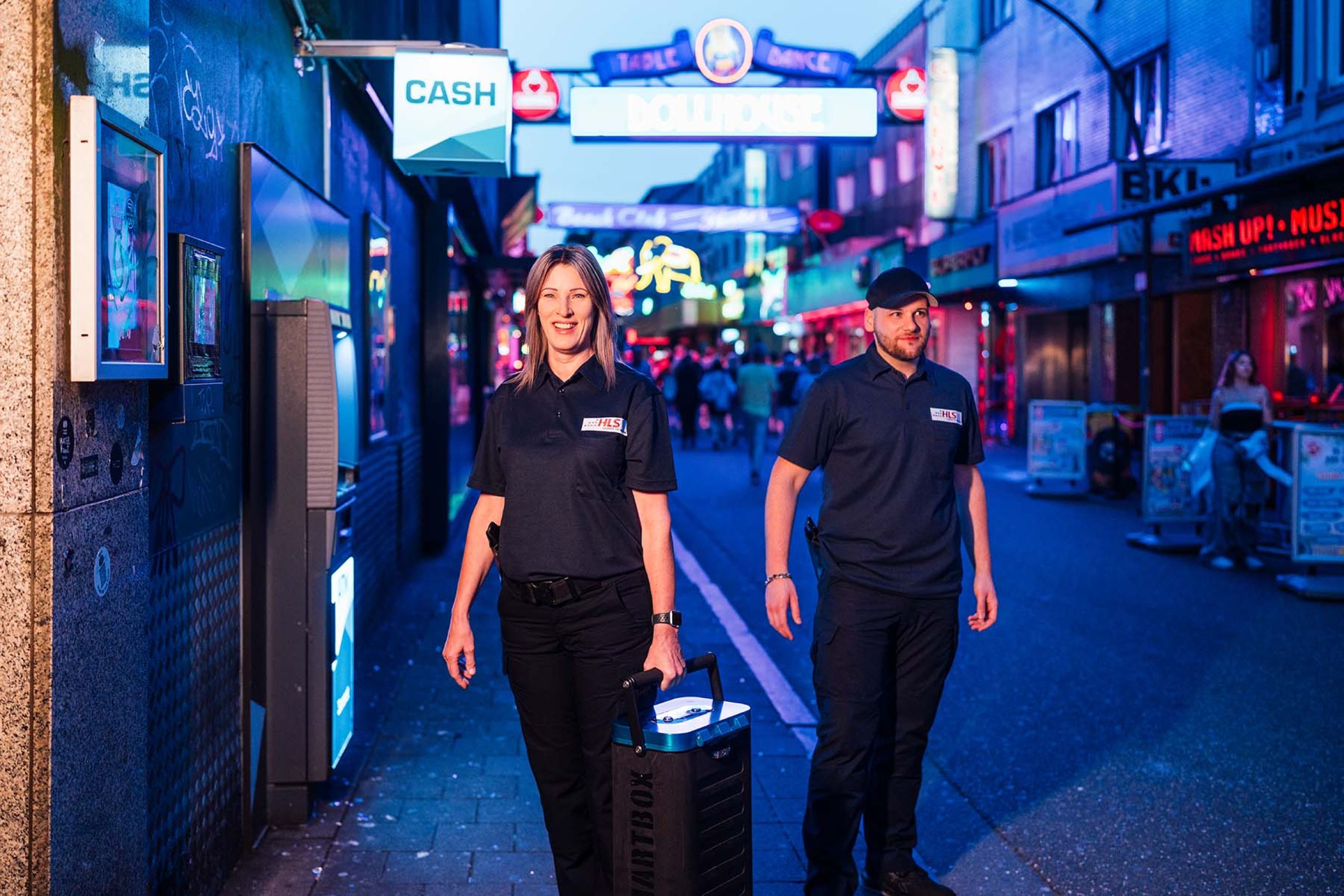 Zwei Mitarbeiter beim Geldtransport auf der Reeperbahn bei Nacht